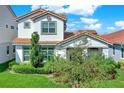 Two-story home featuring a red tile roof, well-maintained lawn, and mature landscaping at 10249 Beechwood Ln, Orlando, FL 32832