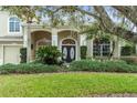 Charming home exterior featuring a well-manicured lawn and decorative double door at 10361 Mallard Landings Way, Orlando, FL 32832