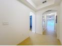 Bright hallway featuring neutral tiling and arched doorways leading to other rooms at 10840 Cabbage Tree Loop, Orlando, FL 32825