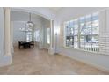 Bright foyer featuring elegant columns, travertine floors, and abundant natural light from large windows at 11237 Camden Park Dr, Windermere, FL 34786