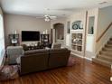 Cozy living room with laminate floors, a ceiling fan and built-in shelving at 11474 Claymont Cir, Windermere, FL 34786