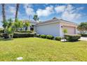 Attractive home showcasing a well-maintained lawn, complemented by lush landscaping and a side entry garage at 1306 Windward Oaks Loop, Auburndale, FL 33823