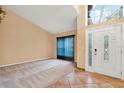 Inviting foyer featuring a decorative glass door and sidelights, along with soaring ceilings and tile flooring at 1341 American Elm Dr, Altamonte Springs, FL 32714