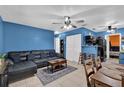 Open living space with bold blue walls, tile flooring, and a view into the adjacent dining and kitchen areas at 1417 Independence Ave, Deltona, FL 32725