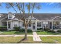 Attractive townhouse featuring a well-manicured lawn, lush landscaping, and inviting curb appeal at 14472 Chinese Elm Dr, Orlando, FL 32828