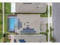 Overhead shot showcasing a home's solar panels, screened-in pool, brick driveway and proximity to neighboring houses at 1472 Rushing Rapids Way, Winter Springs, FL 32708