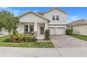 Lovely two-story home with a welcoming front porch and a brick paver driveway, complemented by lush landscaping at 1472 Rushing Rapids Way, Winter Springs, FL 32708