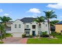 Beautiful two-story home boasts a lush, manicured lawn and mature palm trees for added curb appeal at 15143 Ovation Dr, Winter Garden, FL 34787