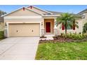 Inviting home exterior with a red door, well-kept lawn, and neutral color palette at 20945 Oldenburg Loop, Mount Dora, FL 32757