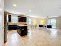 Open-concept living space featuring tile floors, a modern kitchen, and comfortable seating at 20945 Oldenburg Loop, Mount Dora, FL 32757