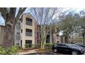 Apartment building exterior showcasing brick and siding with balconies, a parking area, and mature trees at 2200 Metropolitan Way # 926, Orlando, FL 32839