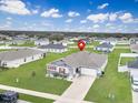 Neighborhood aerial showcasing a home with lush green lawn and a convenient two-car garage in a suburban setting at 2220 Gladiolus Ln, Mascotte, FL 34753