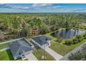 A serene aerial view of a single-story home next to a tranquil pond surrounded by lush greenery at 2875 E Slater Dr, Deltona, FL 32738