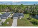 An aerial view of a single-story home with a pond, trees, and a neighboring home at 2875 E Slater Dr, Deltona, FL 32738