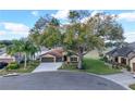 Charming single-story home featuring a well-manicured lawn, mature trees, and a two-car garage at 32107 Spring Meadow Ct., Sorrento, FL 32776