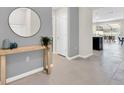 Inviting foyer featuring a round mirror, console table, and neutral color palette at 4058 Lana Avenue, Davenport, FL 33897