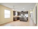 Well-lit kitchen featuring dark cabinetry, stainless steel appliances, and a central island at 5023 Southlawn Ave, Orlando, FL 32811