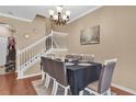 Elegant dining room with a formal table set for six, featuring a staircase and neutral color scheme at 5150 Fiorella Ln, Sanford, FL 32771