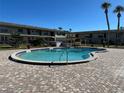 Community pool surrounded by a brick deck and palm trees at 5505 Hernandes Dr # 125, Orlando, FL 32808