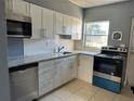 Bright kitchen with white cabinets, stainless steel appliances, and a window at 5505 Hernandes Dr # 125, Orlando, FL 32808