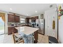 Kitchen with stainless steel appliances, center island with mosaic tile, and dark wood cabinetry at 630 Citrus Isle Blvd, Davenport, FL 33837