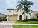 Two-story home with manicured landscaping, a paver driveway, and covered entryway at 12059 Uleta Ln, Orlando, FL 32827