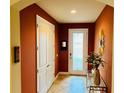 Bright foyer featuring tile floors, decorative mirror and a glass-paneled front door at 12059 Uleta Ln, Orlando, FL 32827