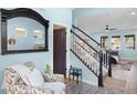 Bright foyer with stairway, chair and decorative mirror at 15373 Murcott Harvest Loop, Winter Garden, FL 34787