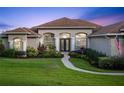 Charming one-story home with a manicured front yard, lush landscaping and walkway to a covered front porch at 16344 Magnolia Bluff Dr, Montverde, FL 34756
