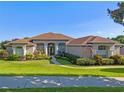 Charming one-story home with a manicured front yard, lush landscaping and walkway to a covered front porch at 16344 Magnolia Bluff Dr, Montverde, FL 34756