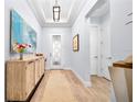 Bright entryway with tray ceiling, decorative console table, and view of the home's interior at 1905 Estuary Ln, Kissimmee, FL 34747