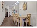 Dining area with wooden table and chairs, carpeted floor, and decorative clock at 506 New Providence Promenade # 506, Davenport, FL 33897