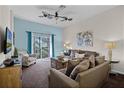 Comfortable living room with a ceiling fan, balcony access, and cozy seating at 506 New Providence Promenade # 506, Davenport, FL 33897