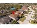 Aerial view of a neighborhood highlighting the home's location in a community with a tennis court at 5251 Wildwood Way, Davenport, FL 33837