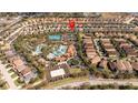 Community aerial view showcases a resort-style pool, clubhouse, playground, and tennis courts at 5251 Wildwood Way, Davenport, FL 33837