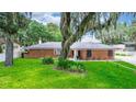 Charming brick home with a well-manicured lawn and mature trees creating a serene setting at 5584 N Dean Rd, Orlando, FL 32817