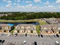 Aerial view of complex overlooking a serene pond and manicured landscaping on a bright, sunny day at 601 Washington Palm Loop, Davenport, FL 33897