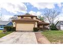 Two-story home with an attached garage, lush landscaping, and a welcoming front entrance at 7440 Windsome Ct, Orlando, FL 32810
