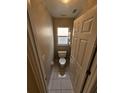 Cozy powder room with neutral walls, tile flooring, a small window, and standard toilet at 7741 Bardmoor Hill Cir, Orlando, FL 32835