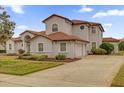 Elegant home with a tile roof, lush landscaping, a circular window and three car driveway at 10616 Emerald Chase Dr, Orlando, FL 32836