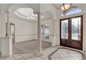 Grand foyer featuring tile floors with decorative inserts, a chandelier, and decorative columns at 10616 Emerald Chase Dr, Orlando, FL 32836