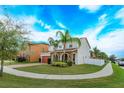 Expansive lawn and mature landscaping surround this beautiful home's brick driveway and architectural details at 1077 Fountain Coin Loop, Orlando, FL 32828