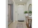 Inviting foyer featuring neutral decor, tiled floors, and an accent table with decorative mirror at 1077 Fountain Coin Loop, Orlando, FL 32828
