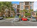 Well-maintained condo building with balconies, landscaping, and ample parking on a sunny day at 1357 Venezia Ct # 402, Davenport, FL 33896
