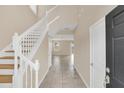 Bright foyer with tile flooring and a staircase leading to the upper level at 14806 Del Morrow Way, Orlando, FL 32824