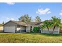 Well-maintained house with a green lawn and mature palm trees enhances its curb appeal at 1585 Randolph St, Deltona, FL 32725