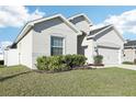 Charming single-Gathering home featuring well-maintained lawn, attached two-car garage, and classic design at 411 Lily Ln, Davenport, FL 33837