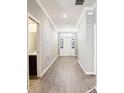 The hallway leads to the front door, it has hardwood floors and a half bathroom on the left at 411 Lily Ln, Davenport, FL 33837