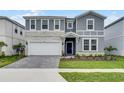 Charming two-story home showcasing a stone facade, landscaped front yard, and covered entrance at 4149 Lana Ave, Davenport, FL 33897