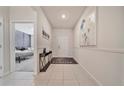 Bright hallway with tile floors, white walls, and decorative artwork at 4149 Lana Ave, Davenport, FL 33897